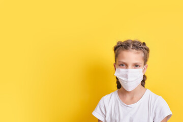 Teenage Girl in protective medical face mask on yellow background