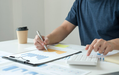 work from home, The hand of a man who works in finance sits at his desk at home and calculates financial graphs showing the results of his investments, planning the steps of his business growth