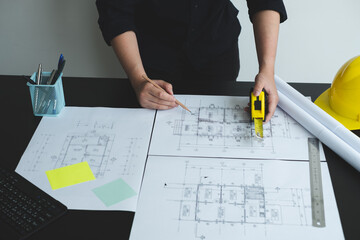 Architects or engineers working construction and drawing construction plans, printing, writing on-site construction sites. Home design concept