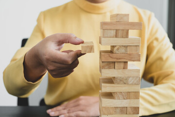 Hands of businesswomen playing wooden block game. Concept Risk of management and strategy plans for business growth and success