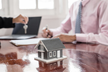 Real estate agent broker hand over the house key to the new owner after completing the signing...