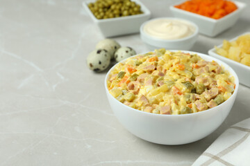 Olivier salad and ingredients on light background