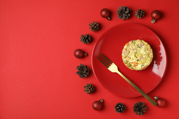 Christmas concept of tasty food with Olivier salad on red background