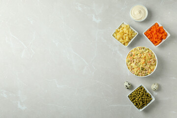 Olivier salad and ingredients on light background