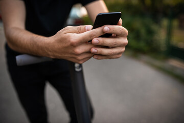 Close up of man hands holding a smart phone on the street
