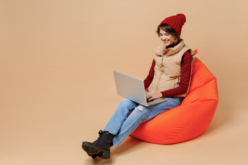 Full body happy fun smiling caucasian young woman 20s wear red turtleneck vest beret sit in bag...