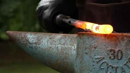 Blacksmith pounding on gun barrel