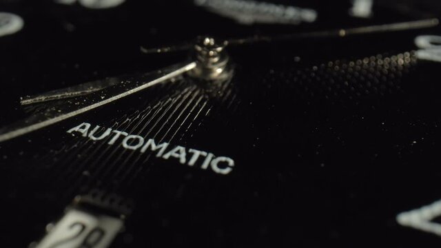 A macro shot of metal seconds hand on the black dial indicates the time. The concept of instruments for measuring time. Watch with logo. High quality. 4k footage.