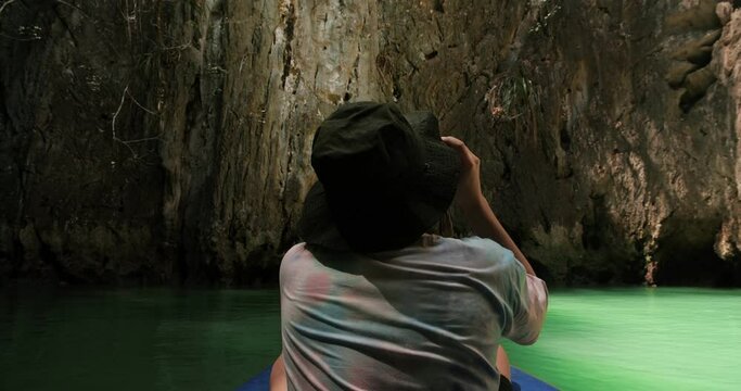 Back view of man tourist on kayak traveling in Ao Phang Nga National Park. Located near Phuket in Thailand. Famous landmark and famous travel destination.