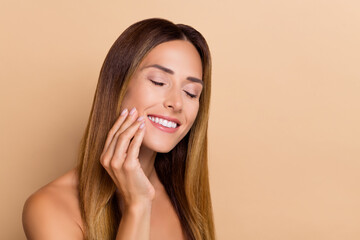 Portrait of attractive cheerful dreamy woman touching perfect skin cosmetic domestic solution...