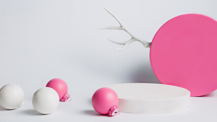 Creative Christmas layout made of podium, antlers and baubles on white background. Minimal Xmas or New year advertisement concept. Mock up showcase for product, promotion, sale or presentation.