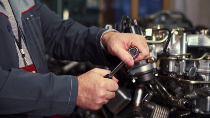 Fototapeta na wymiar An auto mechanic works on a car engine in the mechanics ' garage. Repair services. Close-up