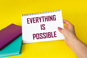 Notepad in woman's hand, with the phrase - everything is possible - conceptual optimism and...
