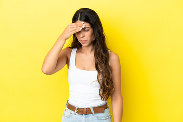 Young caucasian woman isolated on yellow background with headache