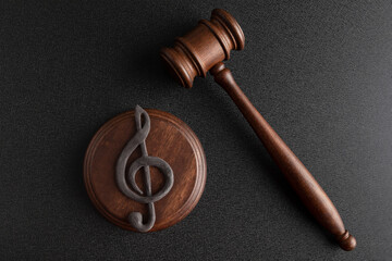 Music symbol treble clef and judge gavel on black background. Music copyright infringement. Music...