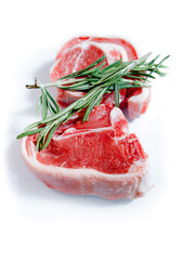 Two juice fresh lamb loin chops with green rosemary herb. White background. Meat industry product. Rich red color. Butcher craft.