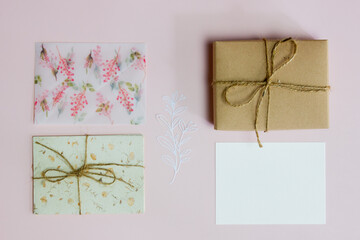 Letter with cute envelope, card and craft box on pink background.