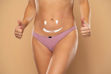Pretty woman with smile drawn on her belly