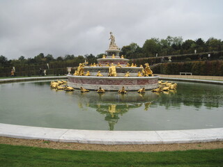 Walk in the evening park. Panoramic landscape with fountains and elegant marble statues in the...