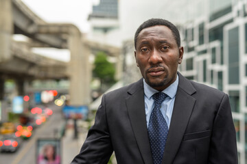 Fototapeta premium Portrait of handsome African businessman in city