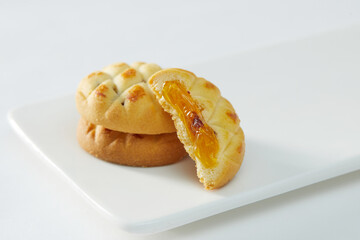 Hand holding biscuits filled with fruity cream. Copy space, Isolated on white 