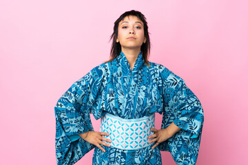 Young woman wearing kimono over isolated blue background angry
