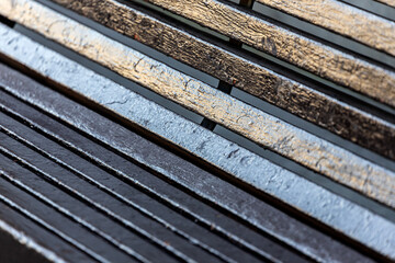 Close-up of a bend in an old painted wooden bench. Wood texture