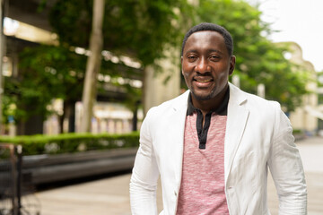 Naklejka premium Portrait of handsome African businessman in city smiling