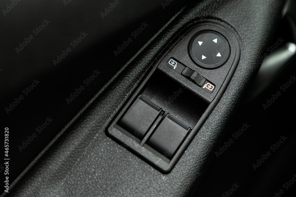 Poster closeup of a door control panel in a new car. arm rest with window control panel, door lock button, 
