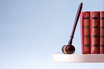 Law concept - Open law book with a wooden judges gavel on table in a courtroom or law enforcement...