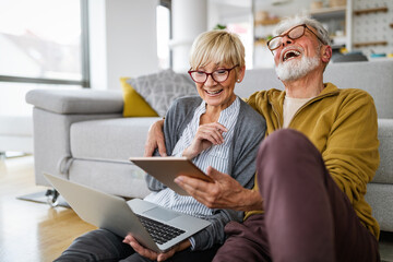Senior couple doing video chat with grandchildren using computer