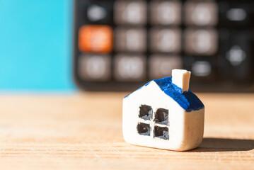 Miniature house blurred calculator. Black blurred calculator.Real estate and mortgage concept.Selective focus,closeup.