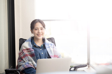 屋外でくつろいでパソコンの仕事をする美しいあアジアの女性