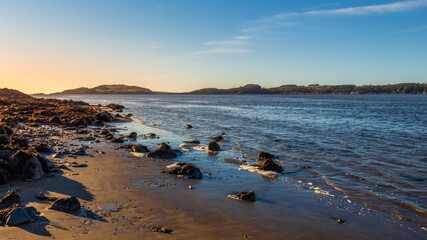 Sunset over a Scottish coastline in winter at a sandy beach at Kirkcudbright Bay