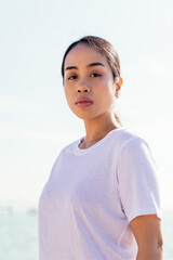 vertical portrait of a serious young asian woman looking at camera