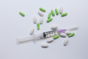 Assorted medical drugs and syringe on white background

