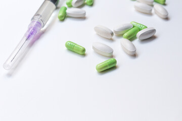 Assorted medical drugs and syringe on white background
