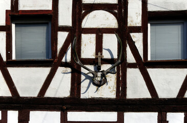Close-up of facade of half-timbered house with Christian cross and antlers, historic part of Forchheim, Forchheim, Franconian Switzerland, Upper Franconia, Franconia, Bavaria, Germany, Europe