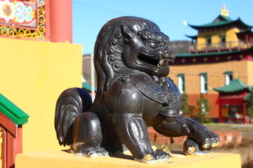 Fototapeta premium Buddhist Snow Lion bronze sculpture protecting temple entrance