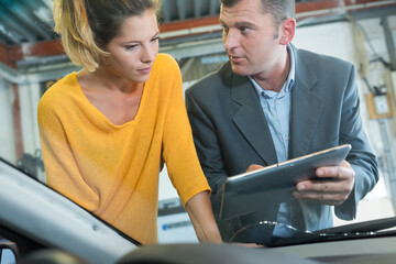 couple checking an automobile windshield