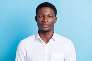 Photo of serious confident dark skin man wear white shirt isolated blue color background