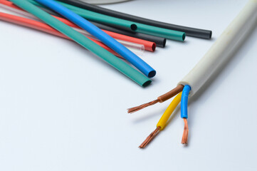 heat shrink tubing and a three-core stripped wire on a white background.