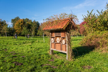 Ein Insektenhotel im Apfelgarten des Plöner Schloßparks im herbstlichen Oktober auf einer Wiese