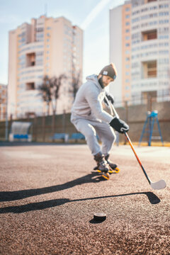 Working with a hockey stick and puck outside the ice on inline skates - rubber coating outdoors for hockey training