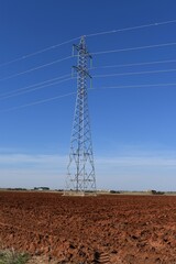 
Power line tower in the middle of a farm field.