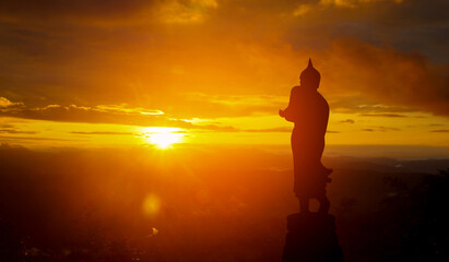 Silhouette buddha statue on sunset background belief of buddhism