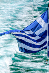 Greek flag waving aboard a ship cruising the Cyclades islands, in the Aegean Sea, Greece, Europe. 
