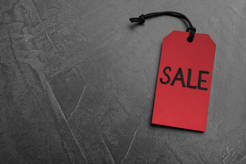 Red tag with word Sale on grey table, top view and space for text. Black Friday