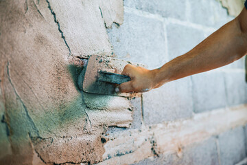 closeup hand of worker plastering cement at wall for building house