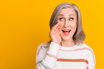 Photo of charming shiny lady pensioner wear pullover arm lips telling you secret looking empty space isolated yellow color background